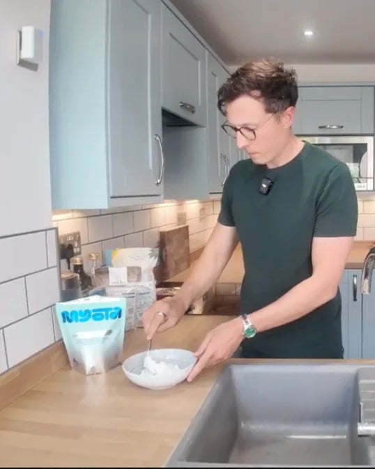 Elliot mixing a scoop in the kitchen
